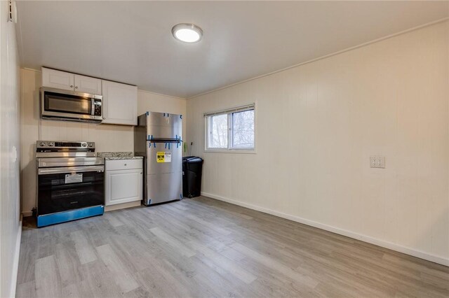 kitchen featuring white cabinets, appliances with stainless steel finishes, baseboards, and light wood finished floors
