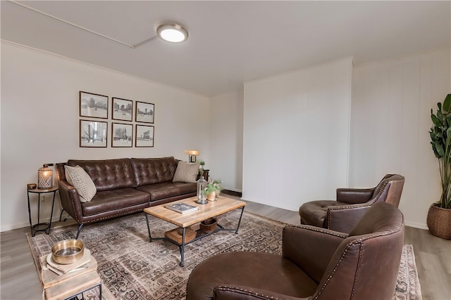 living area featuring wood finished floors, baseboards, and ornamental molding