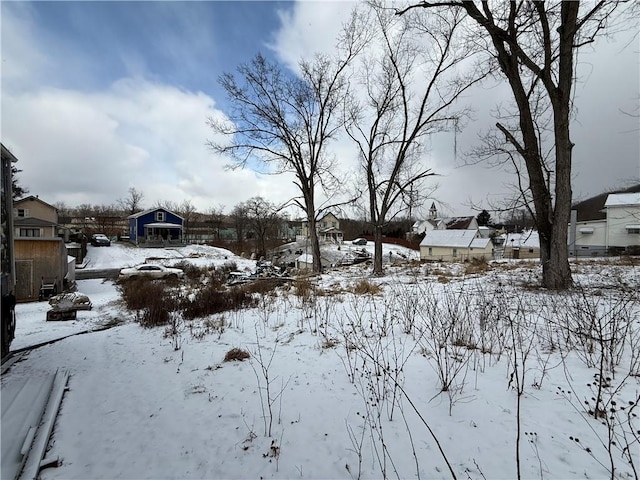 yard covered in snow with a residential view