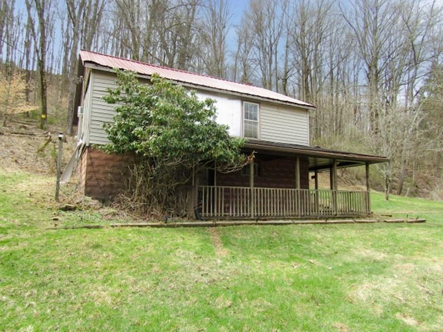 view of front of house with a front yard, metal roof, and covered porch