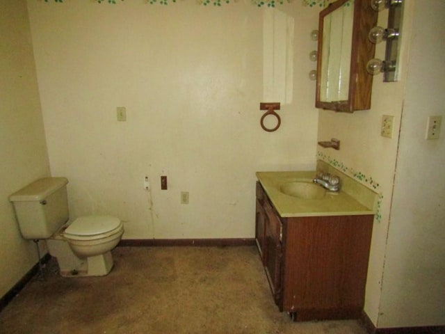 bathroom featuring vanity, baseboards, and toilet
