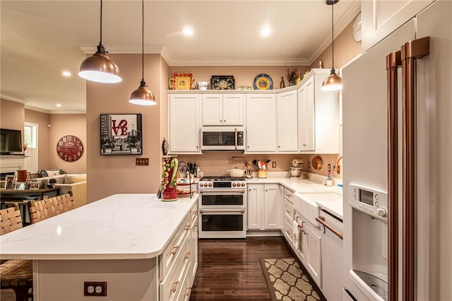 kitchen with premium appliances, a sink, ornamental molding, open floor plan, and dark wood-style floors