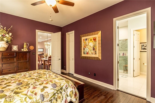 bedroom with dark wood-style flooring, baseboards, a ceiling fan, and ensuite bathroom