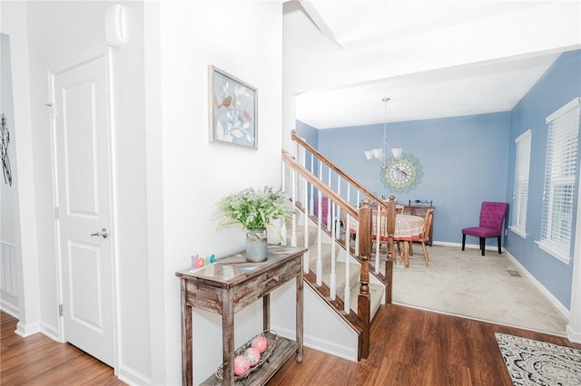 605 Skyline Ct, Irwin, PA 15642 - hallway with baseboards, stairway, a notable chandelier, and wood finished floors