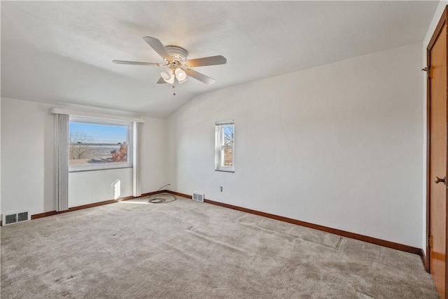 carpeted empty room with a wealth of natural light, visible vents, a ceiling fan, and lofted ceiling
