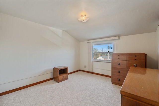 unfurnished office featuring light carpet, baseboards, and lofted ceiling