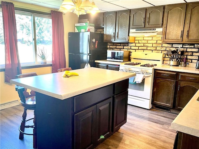 105 Ludwig St, Manorville Boro, PA 16236 - kitchen featuring stainless steel microwave, white range with gas cooktop, light countertops, freestanding refrigerator, and under cabinet range hood