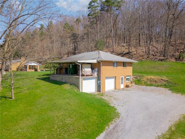 10110 Rinaman Rd, Mccandless, PA 15090 - view of home's exterior with gravel driveway, a lawn, a view of trees, and a garage