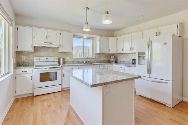 10110 Rinaman Rd, Mccandless, PA 15090 - kitchen with white appliances, under cabinet range hood, light wood-type flooring, tasteful backsplash, and white cabinetry