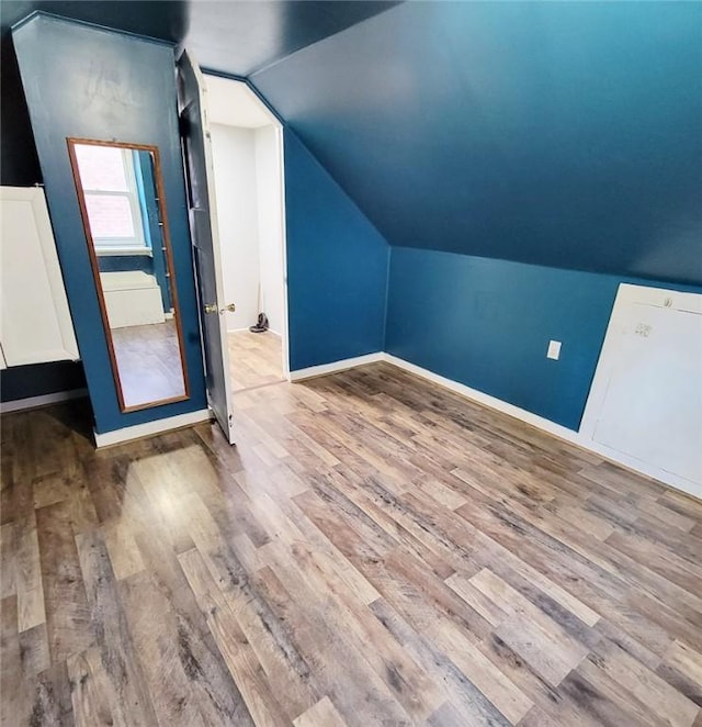 bonus room featuring wood finished floors, baseboards, and lofted ceiling