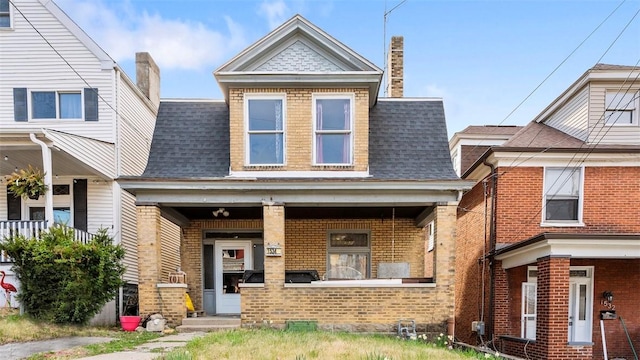 view of front of home featuring brick siding and a shingled roof