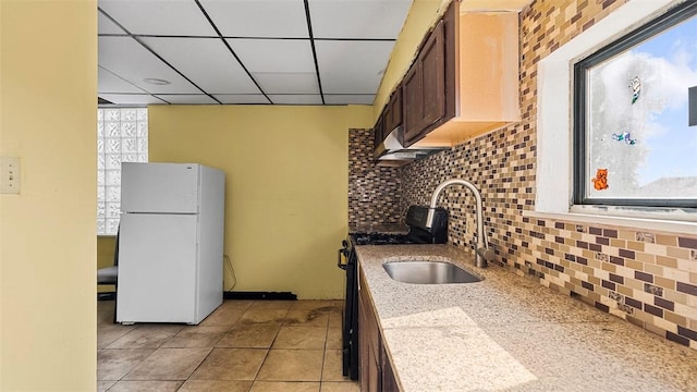 kitchen featuring a healthy amount of sunlight, freestanding refrigerator, decorative backsplash, and black gas range oven