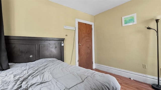 bedroom with baseboards and wood finished floors