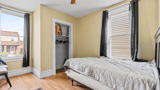 bedroom with a closet, baseboards, ceiling fan, and wood finished floors