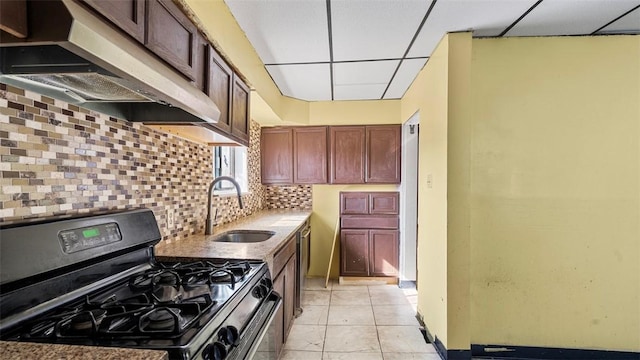 kitchen featuring light tile patterned floors, a sink, under cabinet range hood, stainless steel appliances, and decorative backsplash