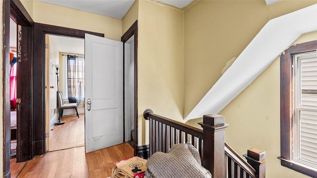 hallway featuring an upstairs landing and wood finished floors