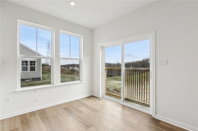 empty room with baseboards, wood finished floors, and visible vents