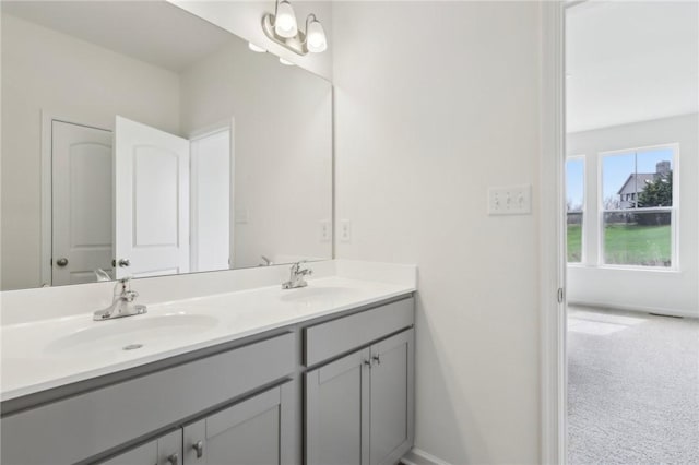 bathroom with double vanity, baseboards, and a sink