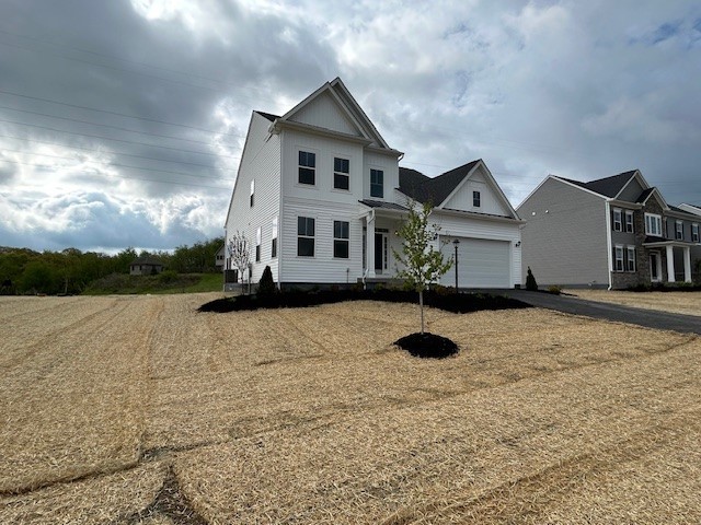 view of front of property featuring board and batten siding, an attached garage, and aphalt driveway