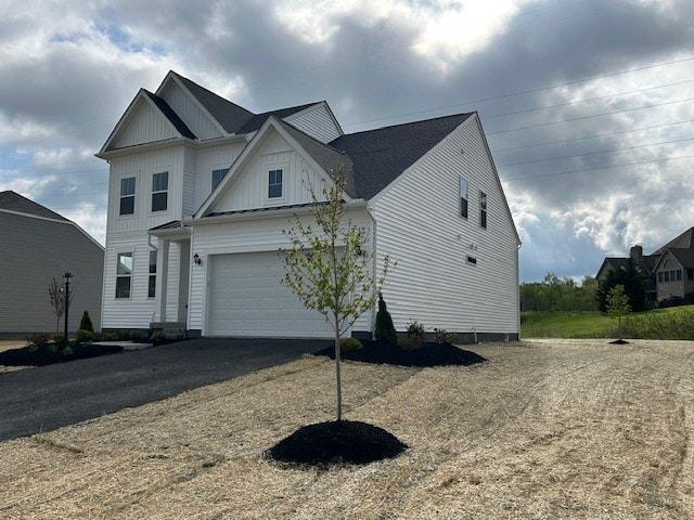 view of front of property with a garage, board and batten siding, and driveway