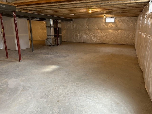 unfinished basement featuring heating unit
