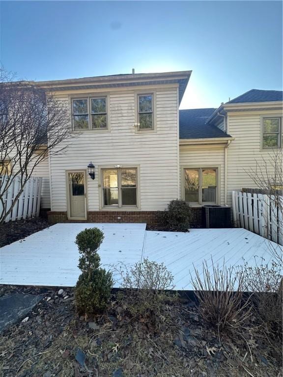 rear view of property with central AC and fence