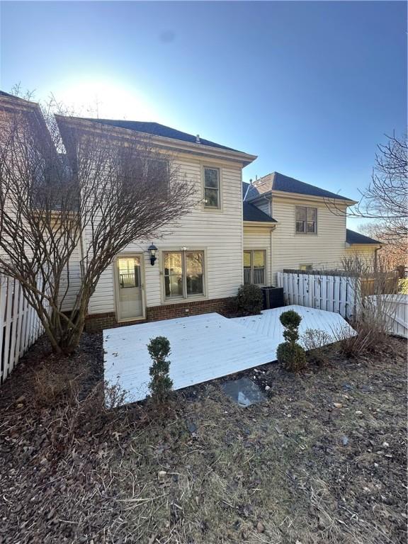 back of house featuring fence and central AC