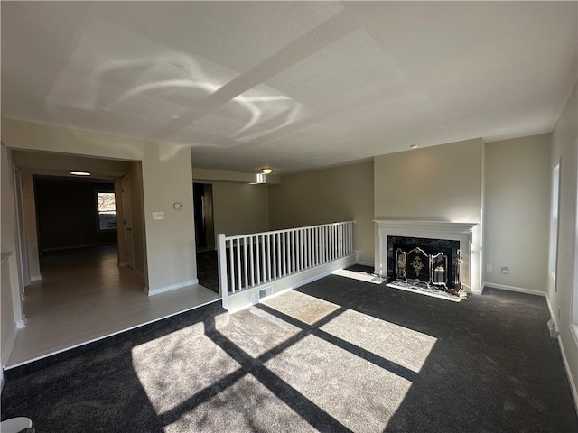 unfurnished living room featuring a high end fireplace, baseboards, and carpet floors