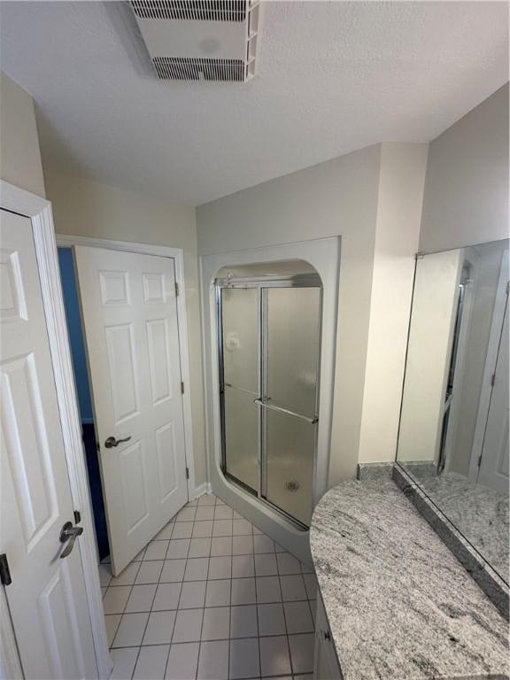 bathroom featuring visible vents, tile patterned floors, and a stall shower