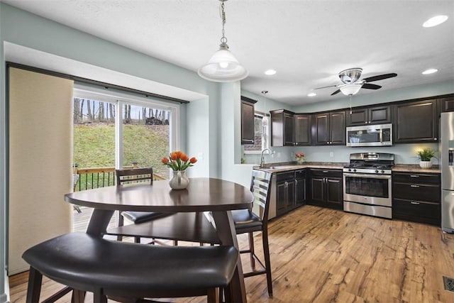 kitchen featuring recessed lighting, light wood finished floors, ceiling fan, and appliances with stainless steel finishes