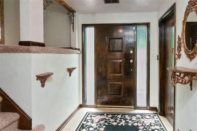 foyer featuring baseboards and visible vents