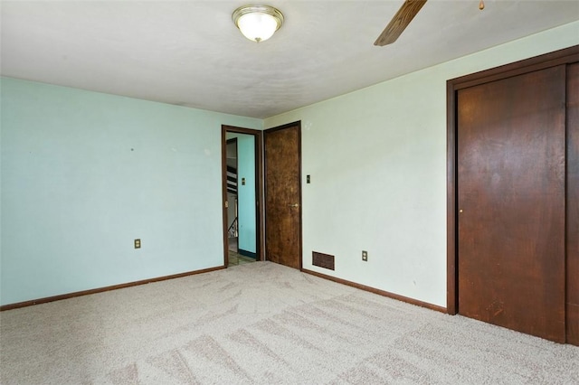 unfurnished bedroom with baseboards, a ceiling fan, visible vents, and carpet floors