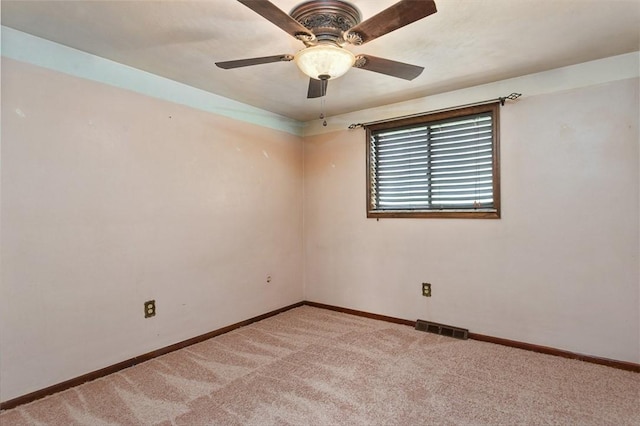 spare room featuring visible vents, baseboards, ceiling fan, and light colored carpet