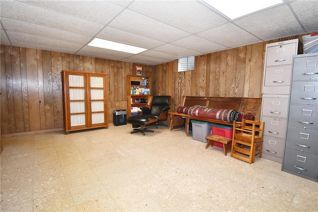office with tile patterned floors, wooden walls, and a drop ceiling