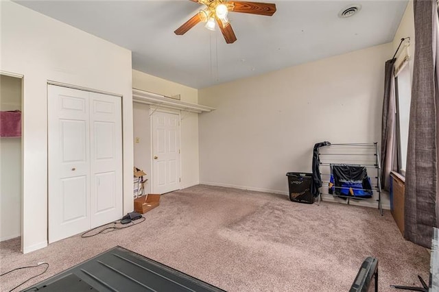 workout area featuring visible vents, ceiling fan, carpet flooring, and baseboards