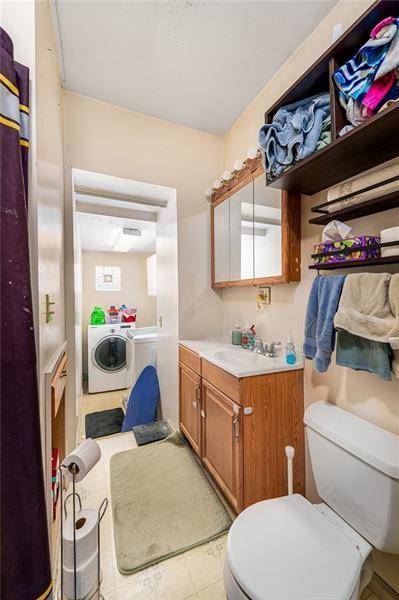 bathroom featuring washer and dryer, vanity, and toilet