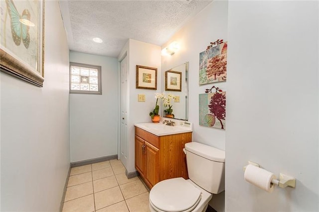 bathroom featuring tile patterned floors, vanity, a textured ceiling, and toilet