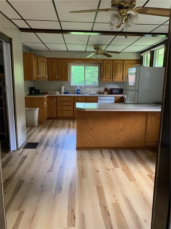 103 Timblin, Clay Twp, PA 16001 - kitchen featuring light wood-style floors, light countertops, a peninsula, white appliances, and brown cabinets