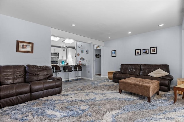 living room with wood finished floors, baseboards, and recessed lighting