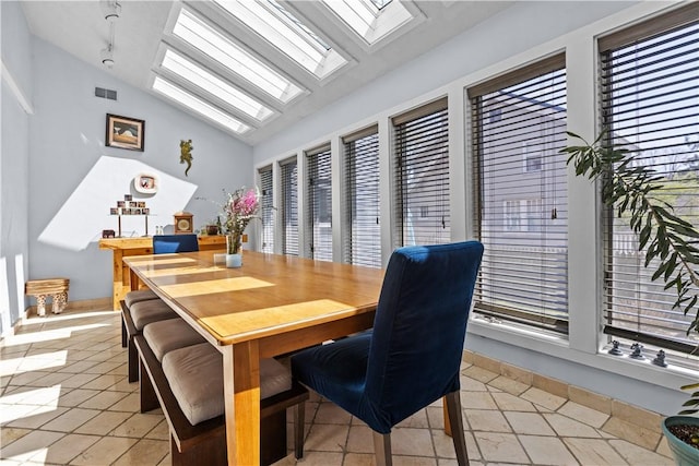 dining room featuring light tile patterned floors, visible vents, and lofted ceiling with skylight