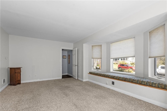unfurnished living room featuring baseboards, visible vents, and carpet floors