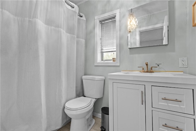 bathroom with vanity, baseboards, and toilet