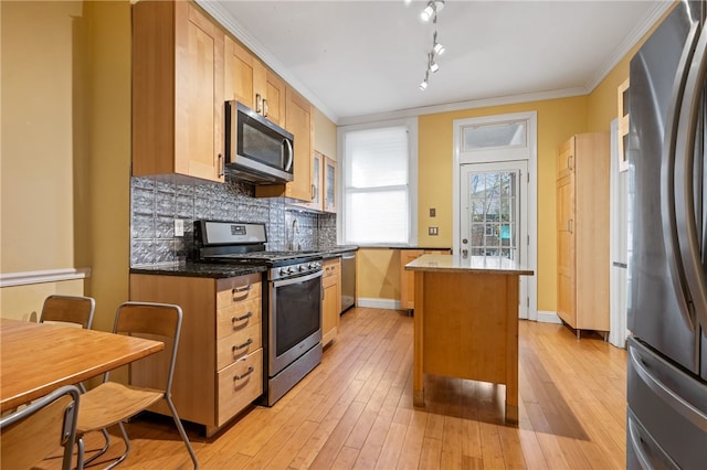 6429 Bartlett St, Squirrel Hill, PA 15217 - kitchen featuring stainless steel appliances, light wood-type flooring, backsplash, and a kitchen island