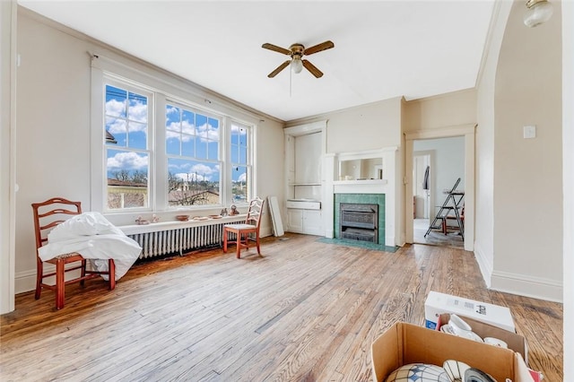 43-45 Union St, Uniontown, PA 15401 - interior space featuring baseboards, a tiled fireplace, a ceiling fan, radiator, and wood finished floors