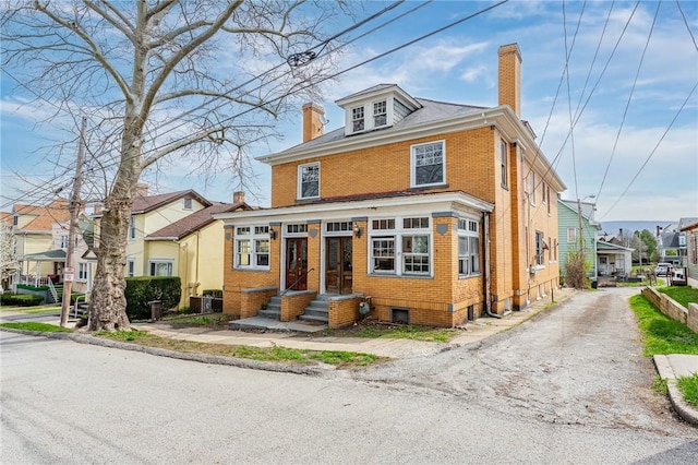 43-45 Union St, Uniontown, PA 15401 - traditional style home with brick siding, central air condition unit, driveway, and a chimney
