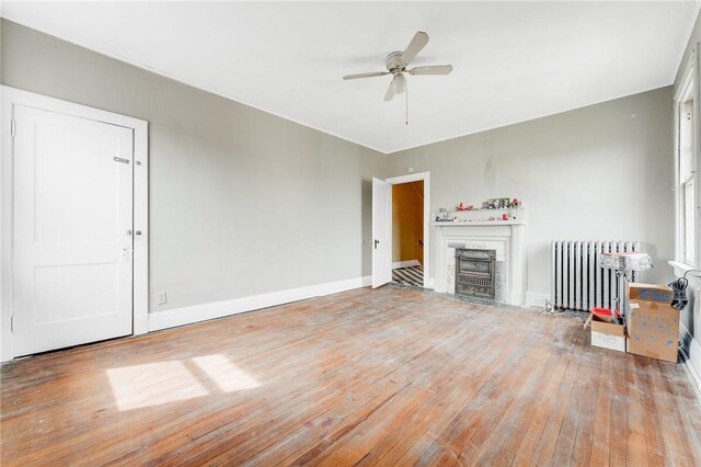 43-45 Union St, Uniontown, PA 15401 - living room with baseboards, a ceiling fan, a fireplace, radiator heating unit, and hardwood / wood-style floors