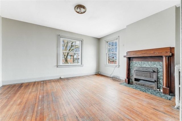 43-45 Union St, Uniontown, PA 15401 - unfurnished living room with a tiled fireplace, baseboards, and hardwood / wood-style floors