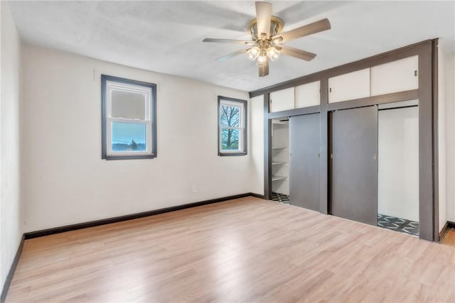 2444 Dewey St, Homestead, PA 15120 - unfurnished bedroom featuring baseboards, a ceiling fan, two closets, and wood finished floors