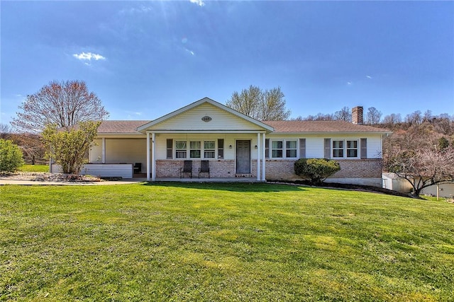 ranch-style home with brick siding, a chimney, a front lawn, and covered porch