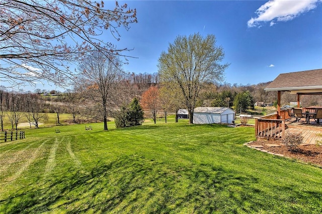 view of yard with an outbuilding, fence, and a deck